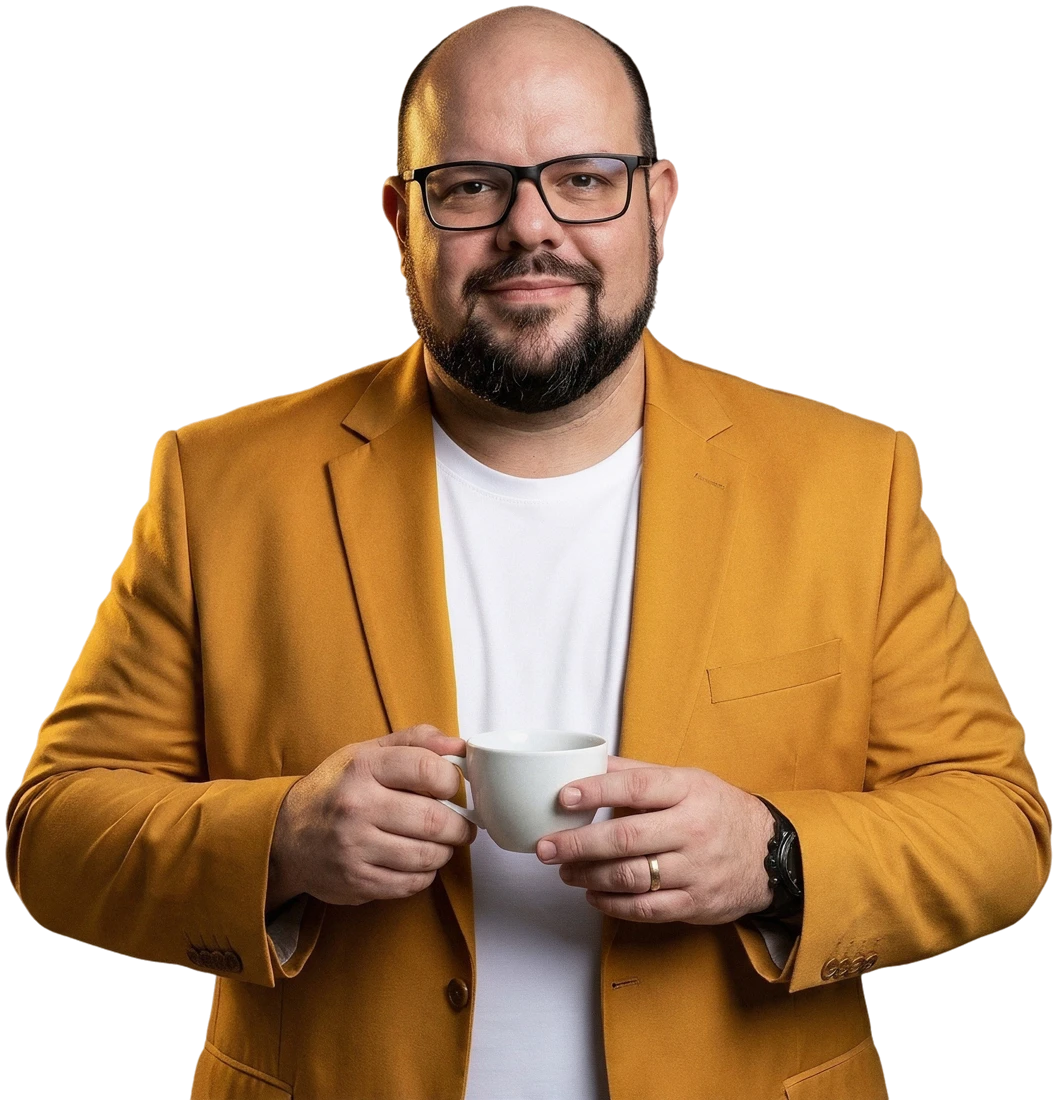 Flávio Sabugo segurando uma xícara de café, blazer amarelo e camiseta branca