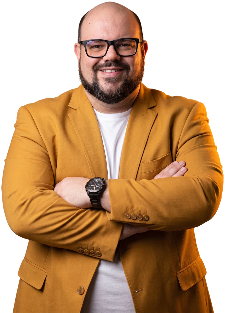Flávio Sabugo de braços cruzados, retrato de estúdio com blazer amarelo